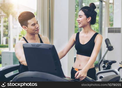 Sporty runner running on treadmill in fitness gym. Healthy lifestyle concept.