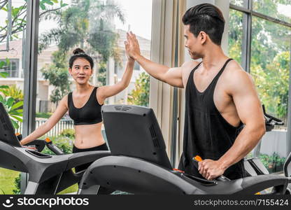 Sporty runner running on treadmill in fitness gym. Healthy lifestyle concept.