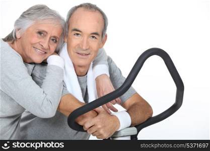 Sporty senior couple with cross trainer