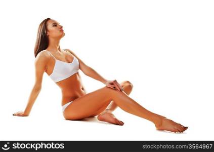 Sporty sexy woman siting on the floor on white background