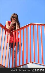 Sporty style. Trendy cool teenage girl on the urban bridge. Copy space on blue sky. Summer.