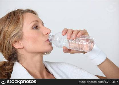 Sporty woman drinking bottle of water