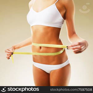 sporty woman in white and measure around her body