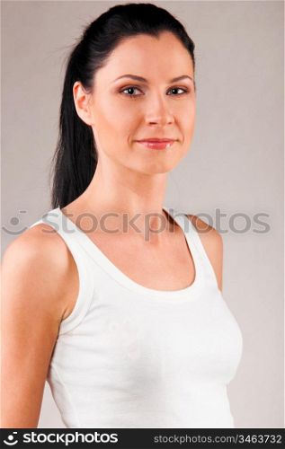 sporty woman is standing on grey background