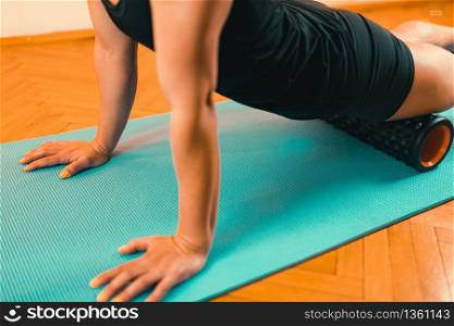Sporty Woman Massaging Her Legs with Foam Roller . Foam Roller Quadriceps Massage