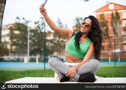 Sporty woman taking selfies at the park