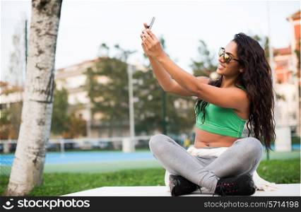 Sporty woman taking selfies at the park