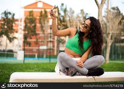 Sporty woman taking selfies at the park