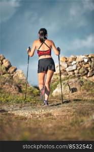 Sporty woman with beautiful athletic physique with ski poles during in excursion