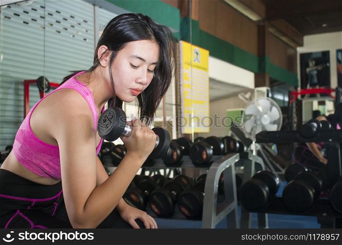 Sporty woman with dumbell in hand