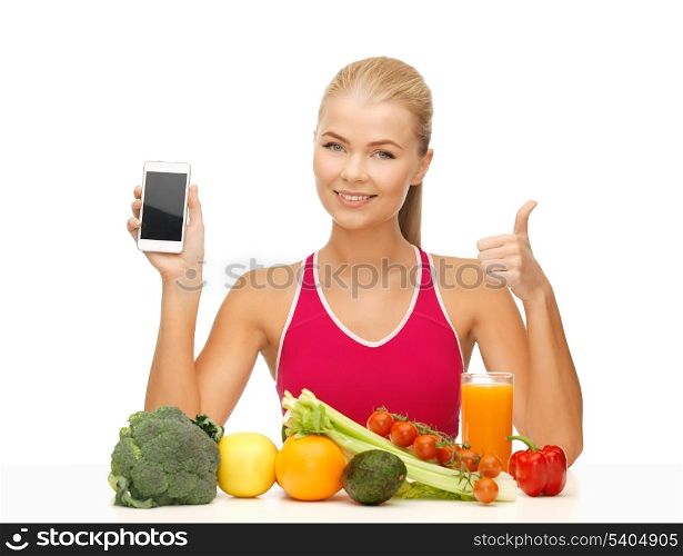 sporty woman with fruits and vegetables showing smartphone