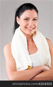 sporty woman with towel on shoulders on grey background