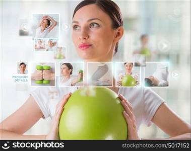 Sporty woman working out using modern virtual interface. Online fitness trainer concept
