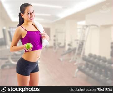 Sporty young girl with apple at gym club