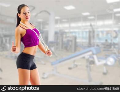 Sporty young girl with skipping rope at gym club