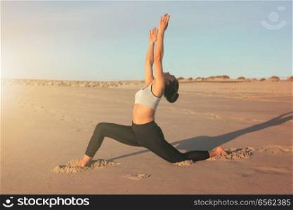 Sporty young woman doing yoga practice at the beach - concept of healthy life and natural balance between body and mental development