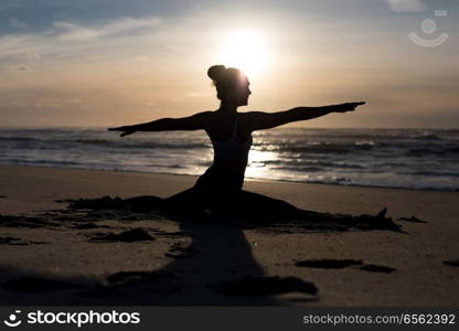 Sporty young woman doing yoga practice at the beach - concept of healthy life and natural balance between body and mental development