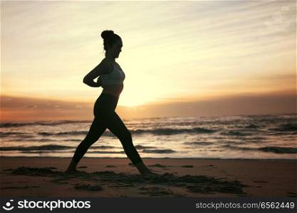 Sporty young woman doing yoga practice at the beach - concept of healthy life and natural balance between body and mental development