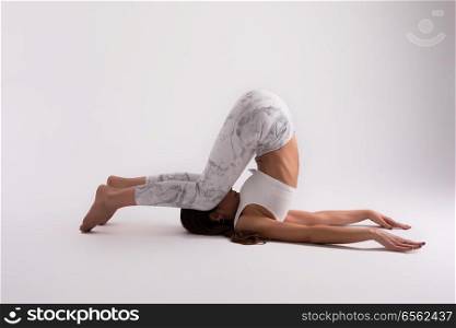 Sporty young woman doing yoga practice isolated on white background - concept of healthy life and natural balance between body and mental development