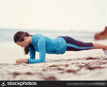 Sporty young woman exercising on the sea coast