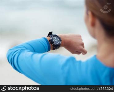 Sporty young woman looking at her watches