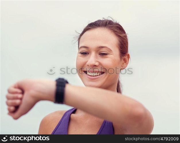 Sporty young woman looking at her wristwatch