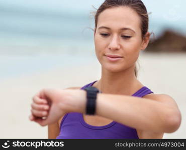 Sporty young woman looking at her wristwatch