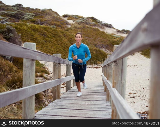 Sporty young woman running up the stairs