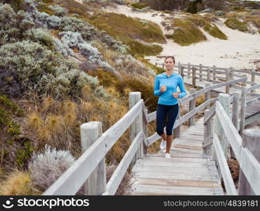 Sporty young woman running up the stairs