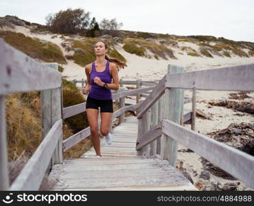 Sporty young woman running up the stairs