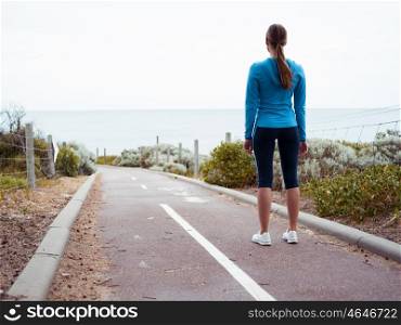 Sporty young woman standing and gettng eady for a run