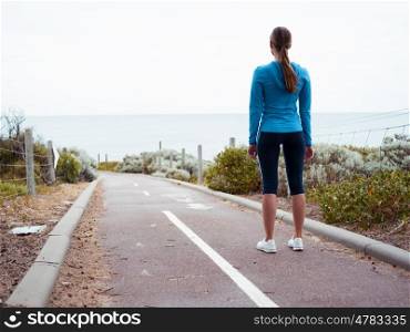 Sporty young woman standing and gettng eady for a run