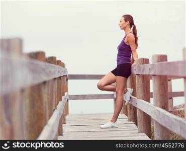 Sporty young woman standing and looking at sea