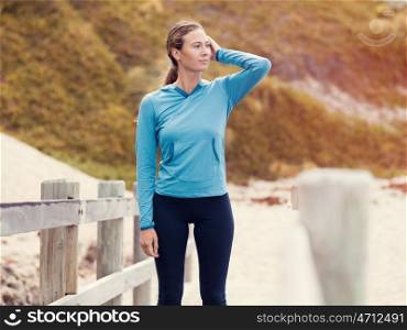 Sporty young woman standing not far from the beach