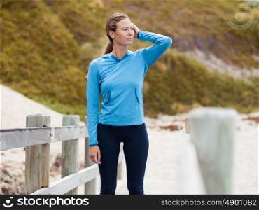 Sporty young woman standing not far from the beach