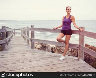 Sporty young woman standing on the sea coast