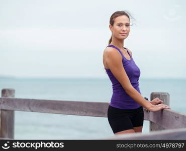 Sporty young woman standing on the sea coast