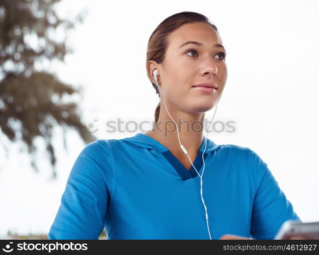 Sporty young woman with a phone and earphones