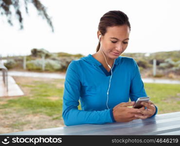 Sporty young woman with a phone and earphones