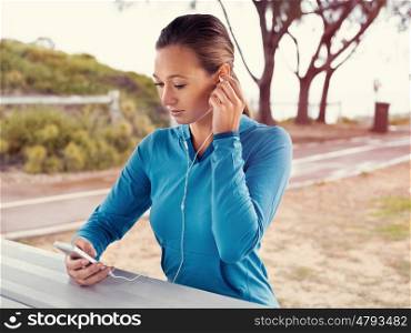 Sporty young woman with a phone and earphones