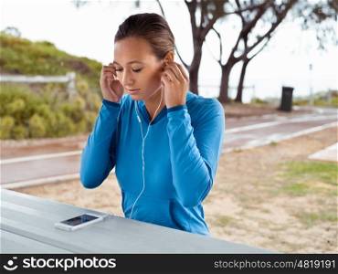 Sporty young woman with a phone and earphones
