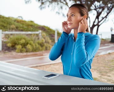 Sporty young woman with a phone and earphones