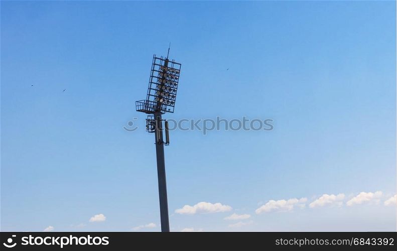 Spotlight on lighting tower of stadium on blue skye background. Spotlight on lighting tower of stadium