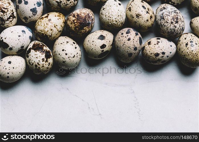 Spotted quail eggs on a white marble background. Easter traditions. Copyspace.. Spotted quail eggs on white marble background.