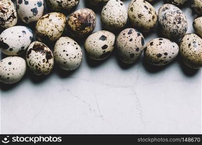 Spotted quail eggs on a white marble background. Easter traditions. Copyspace.. Spotted quail eggs on white marble background.