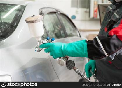 spray gun with paint for painting a car . painting a car