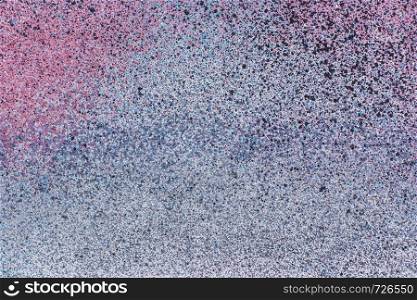 spray of colored aerosol paint on a grey metallic surface. abstract background, texture