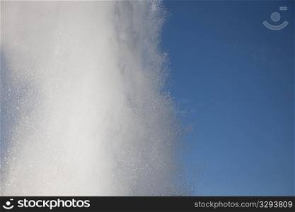 Spray of geyser steam in the blue sky