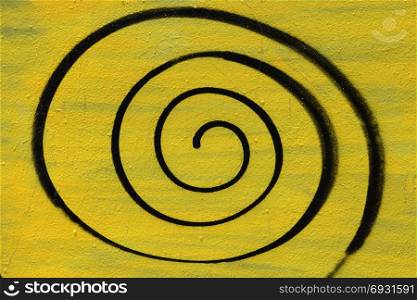 Spray painted spiral on textured wall background. Abstract geometric shape.
