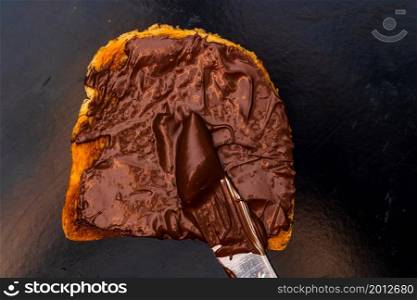 Spreading chocolate cream on toasted bread